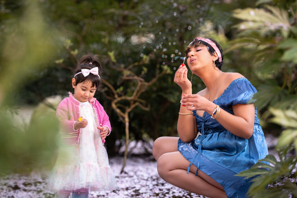 Mom blowing bubbles during her family's cherry blossom photoshoot.